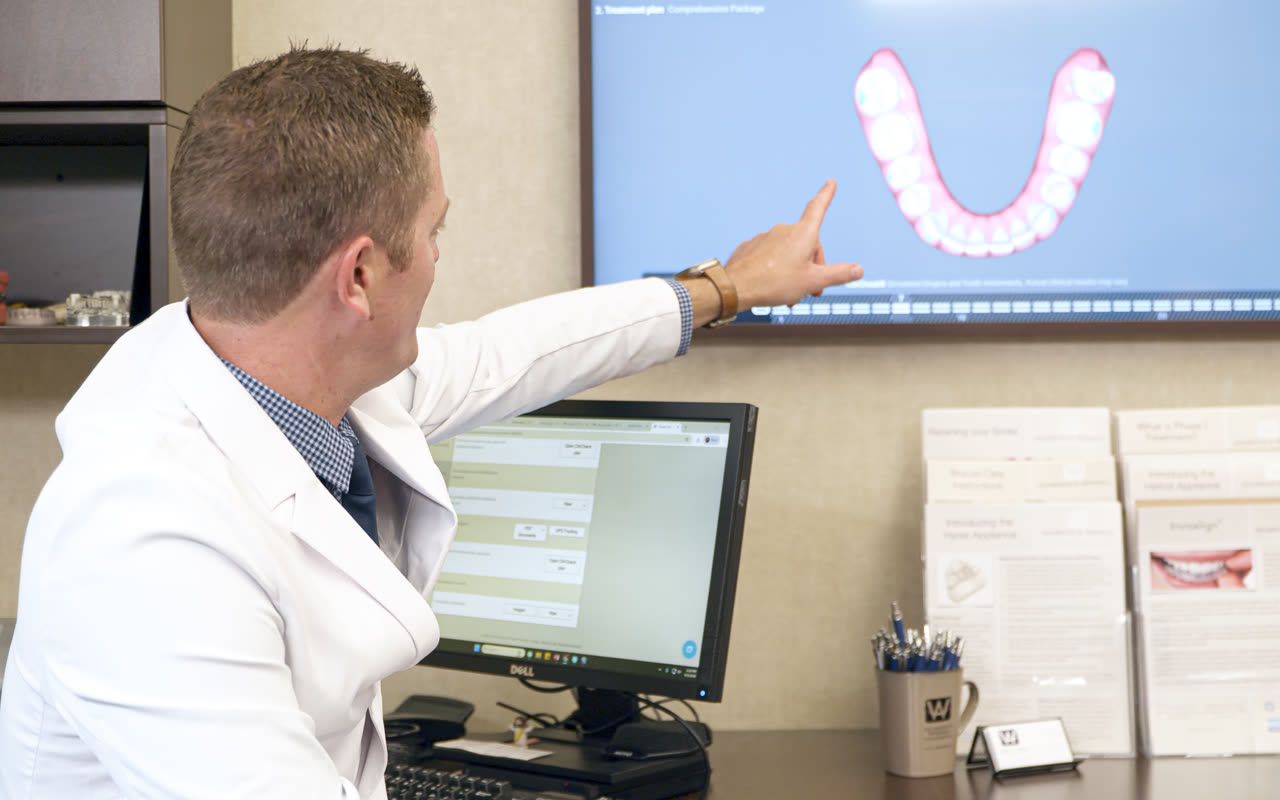 Orthodontist reviewing an Invisalign® treatment plan with a patient in Grand Rapids, MI