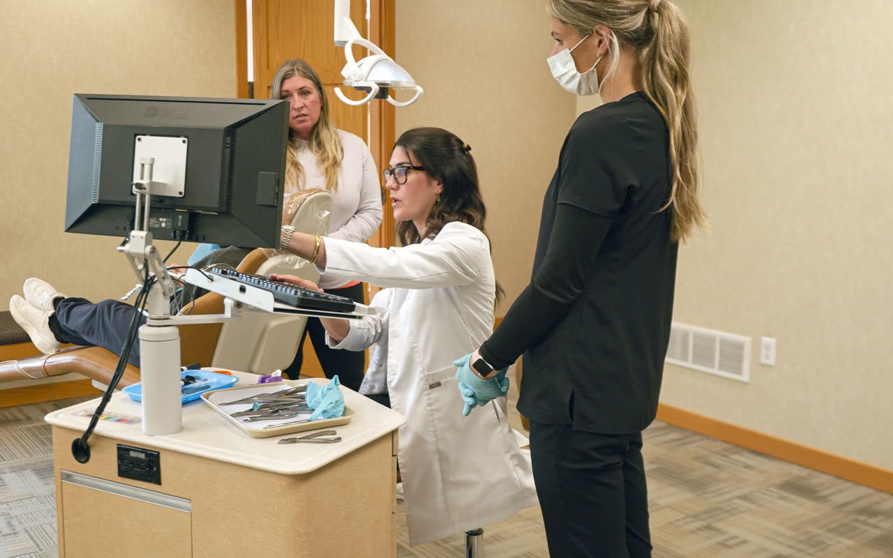 Orthodontist reviewing a digital treatment plan with an adult patient in Grandville, MI