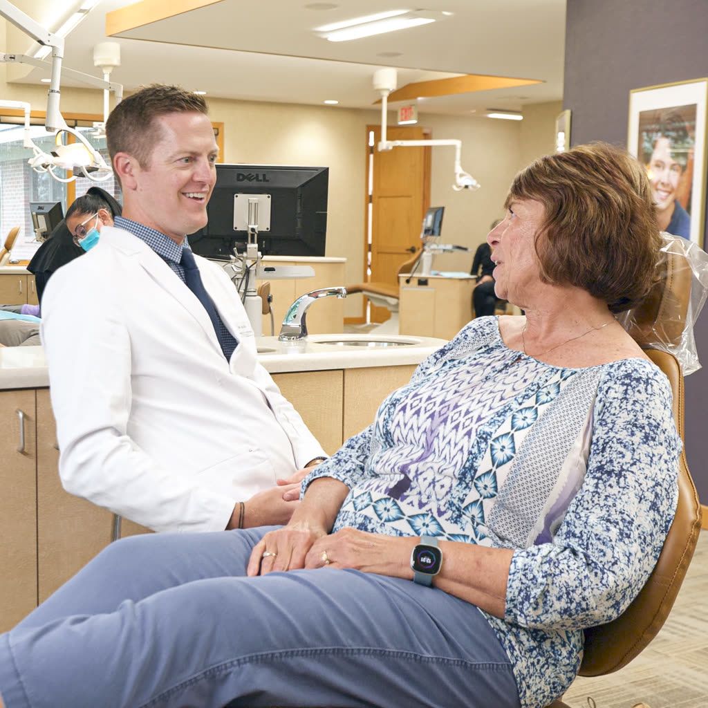 Orthodontist sharing a warm conversation with a longtime patient at our Grandville, MI office
