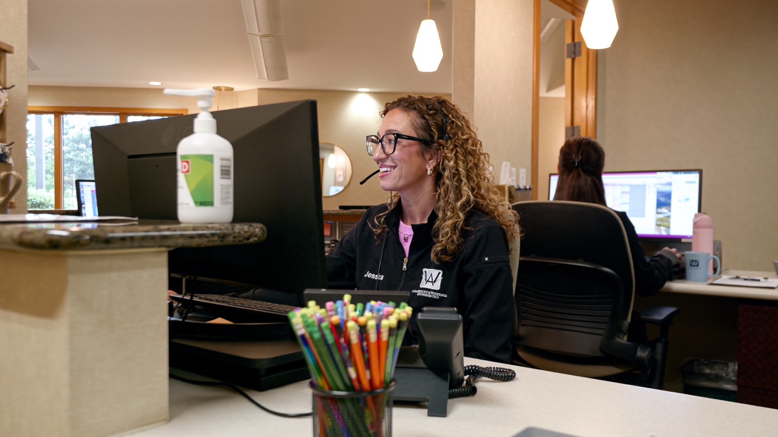 Front desk team member Jessica assisting a patient at our Grand Rapids, MI orthodontic office