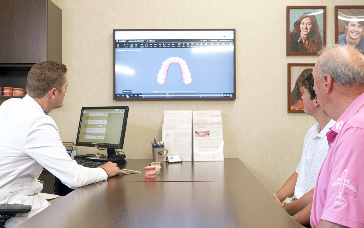 Orthodontist reviewing a ceramic braces treatment plan with a patient at our Grand Rapids, MI office