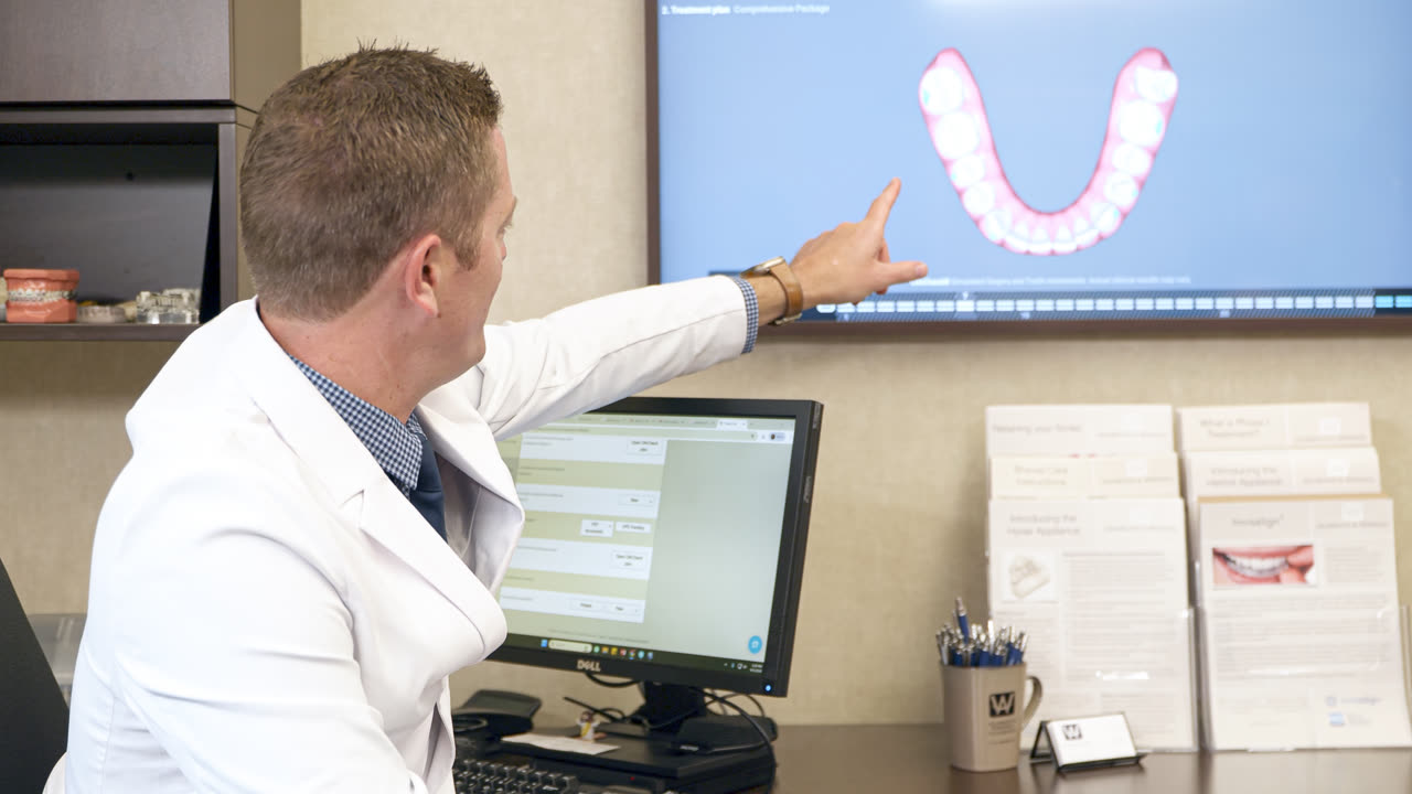 Orthodontist reviewing an Invisalign® treatment plan on screen at our Grandville, MI office