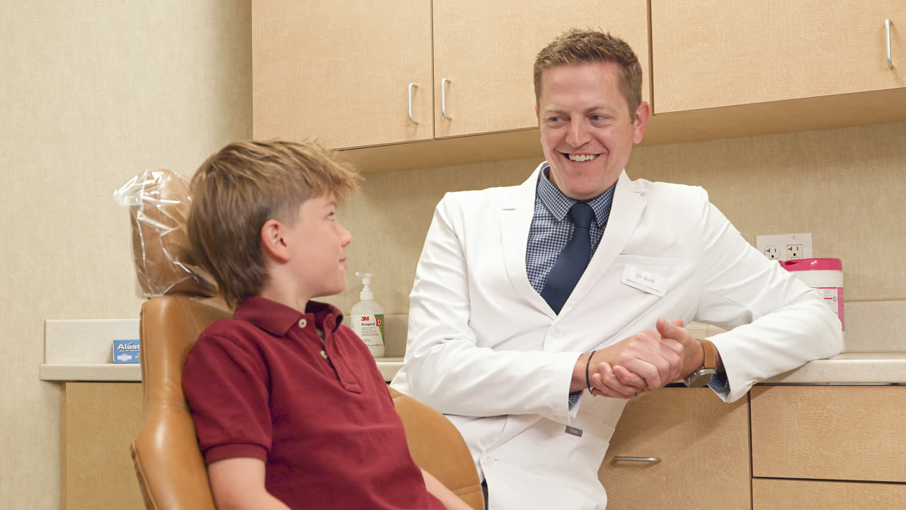 Orthodontist discussing metal braces timing with a young patient in Grand Rapids, MI