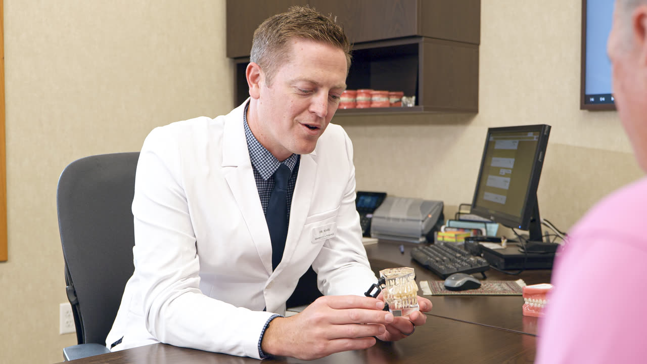 Orthodontist showing a patient a model of their treatment plan at our Grandville, MI office