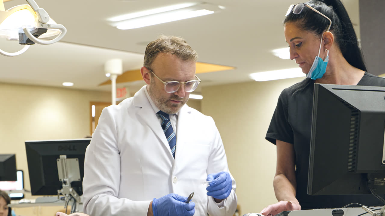 Orthodontist and dental assistant reviewing a patient's care at our Grandville, MI office