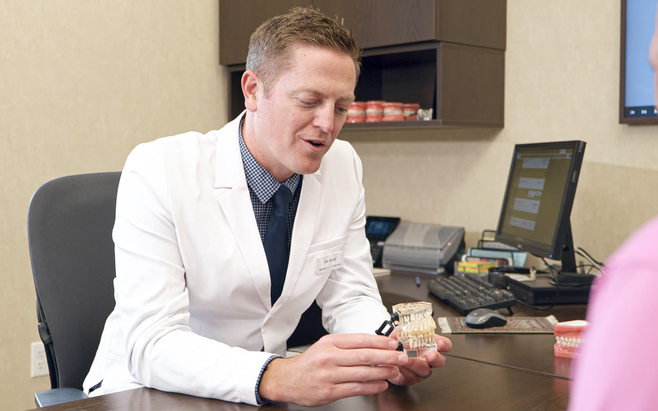 Orthodontist Dr. Mark Wierenga showing a patient a bracket model at our Grandville, MI office