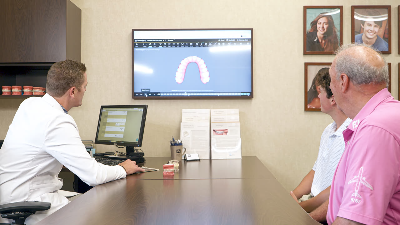 Orthodontist reviewing a digital scan with a teen patient and parent at our Grand Rapids, MI office